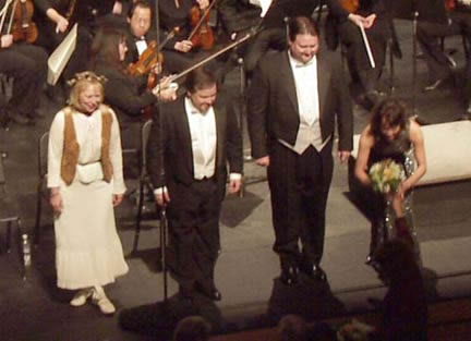 Taking bows and accepting flowers after a standing ovation.